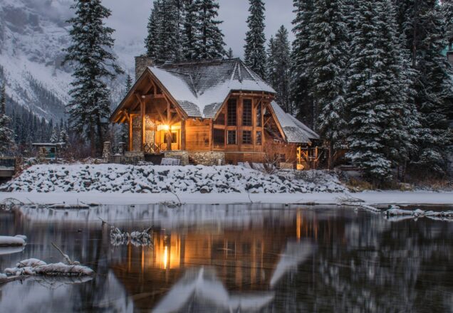 Wooden house surrounded by snow-covered pine trees