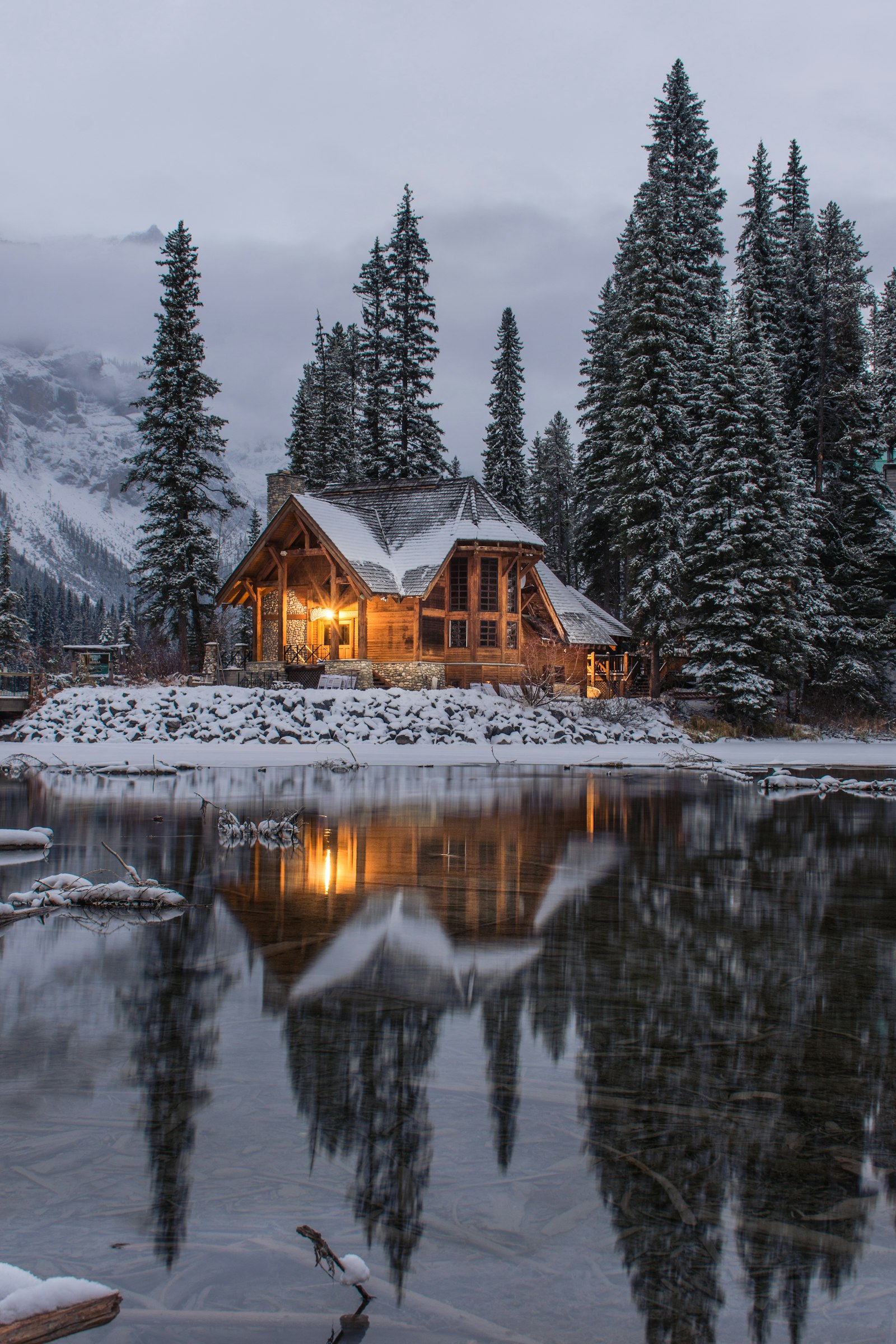 Wooden house surrounded by snow-covered pine trees